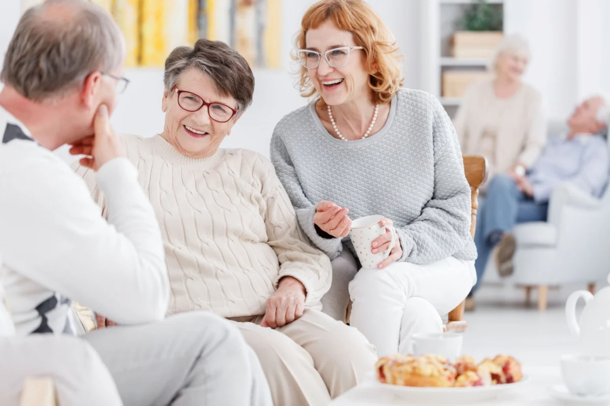 Smiling seniors enjoying a relaxed conversation in a bright aged care setting